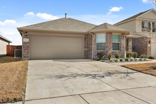 ranch-style home featuring a garage and cooling unit