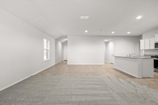 unfurnished living room featuring light colored carpet and lofted ceiling