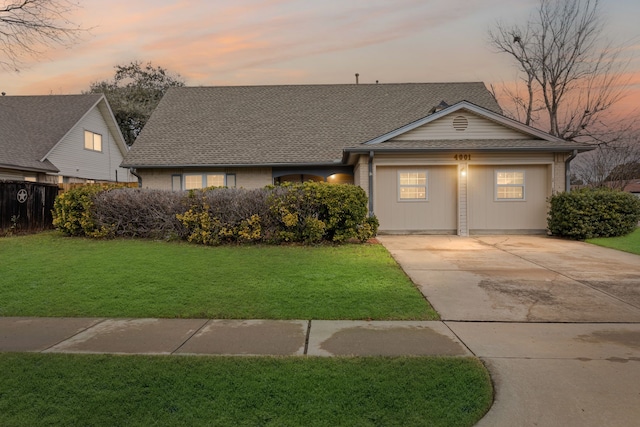 view of front of house with a garage and a lawn