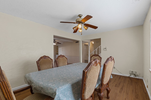 dining space featuring hardwood / wood-style floors, a textured ceiling, and ceiling fan