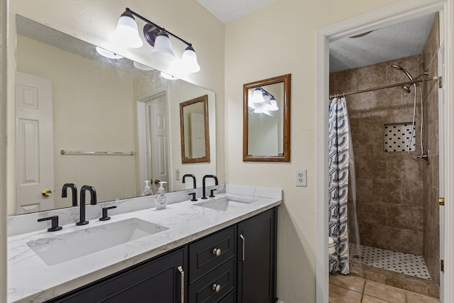 bathroom featuring a shower with curtain, vanity, tile patterned flooring, and a textured ceiling