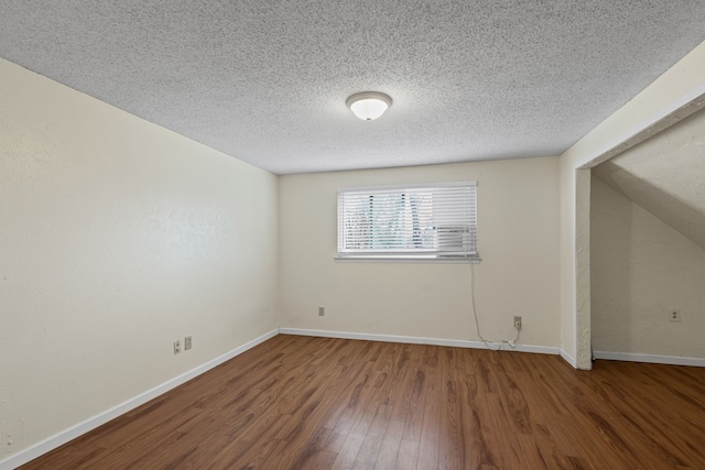 unfurnished room with dark wood-type flooring and a textured ceiling