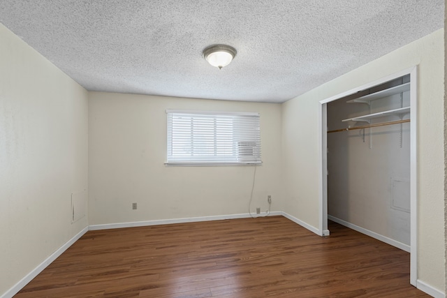 unfurnished bedroom featuring dark hardwood / wood-style floors, a textured ceiling, and a closet