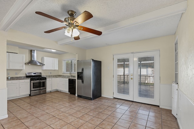 kitchen featuring french doors, white cabinets, appliances with stainless steel finishes, and wall chimney range hood