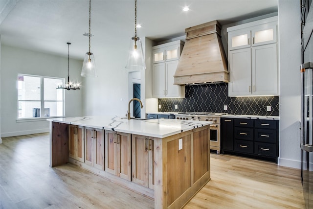 kitchen with white cabinetry, premium range hood, a large island, and range with two ovens