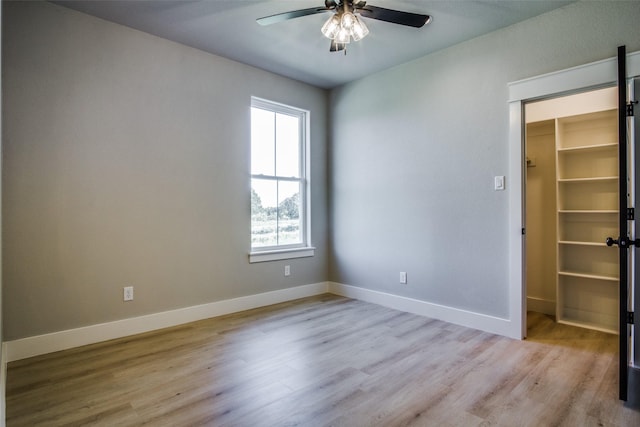 empty room with light hardwood / wood-style floors and ceiling fan