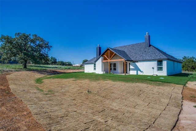 rear view of house with a yard