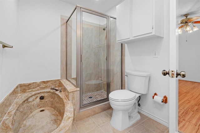 bathroom featuring tile patterned flooring, ceiling fan, a shower with door, and toilet