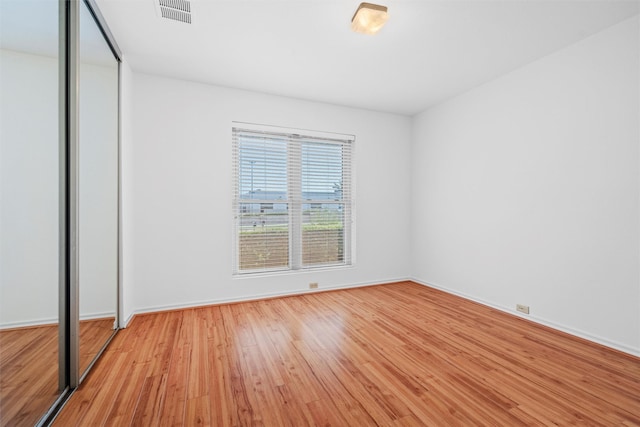 unfurnished bedroom featuring light hardwood / wood-style floors and a closet