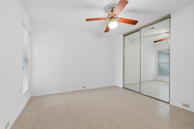 unfurnished bedroom featuring ceiling fan and a closet