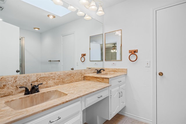 bathroom featuring tile patterned flooring, vanity, and a skylight