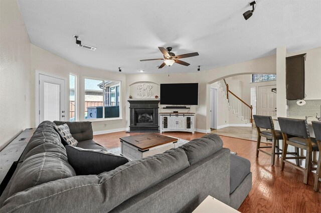 kitchen with ceiling fan with notable chandelier, decorative light fixtures, dishwasher, sink, and light stone countertops