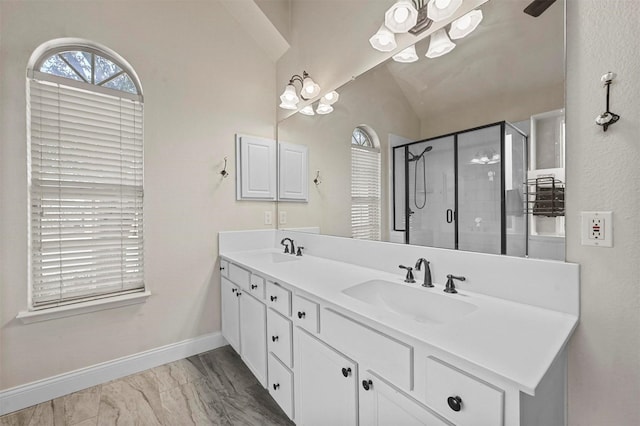 bathroom featuring lofted ceiling, an enclosed shower, vanity, and a healthy amount of sunlight