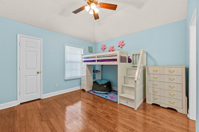 bedroom featuring ceiling fan, light hardwood / wood-style floors, and lofted ceiling