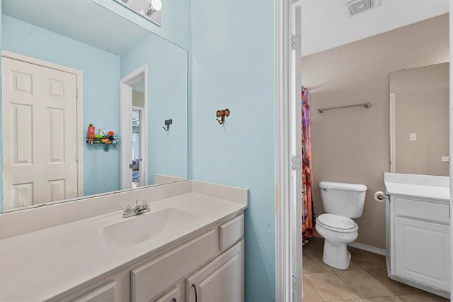 bathroom with vanity, toilet, and tile patterned floors