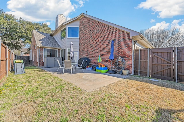 back of house with a lawn and a patio area