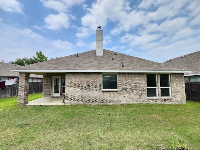 rear view of property with a patio and a lawn