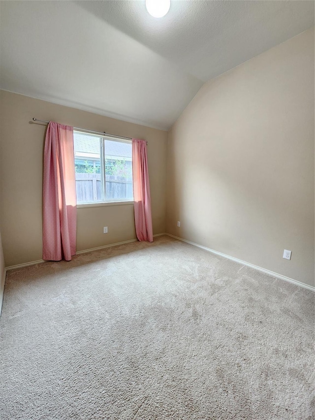 unfurnished room with lofted ceiling and carpet floors