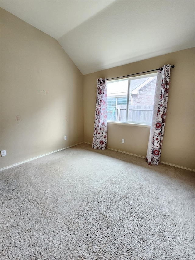 carpeted spare room featuring lofted ceiling