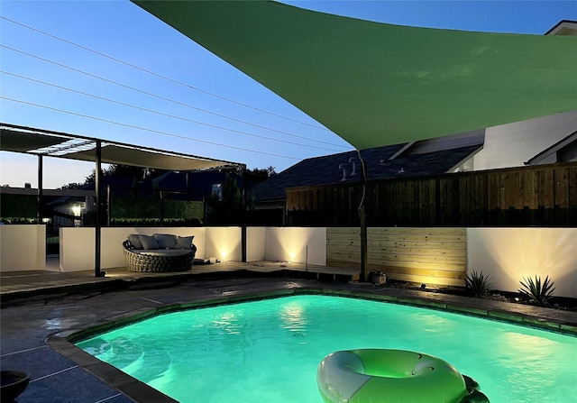 pool at dusk featuring an outdoor living space and a patio area