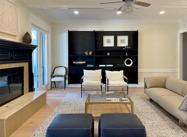 living room featuring crown molding, light hardwood / wood-style floors, and ceiling fan