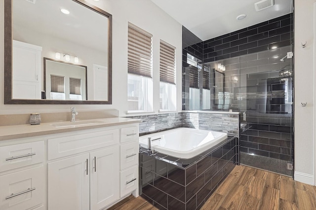 bathroom with vanity, plus walk in shower, and hardwood / wood-style floors