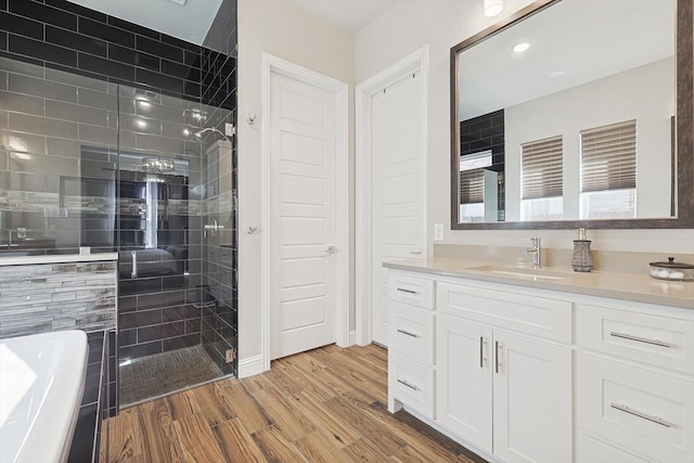 bathroom with vanity, plus walk in shower, and hardwood / wood-style floors