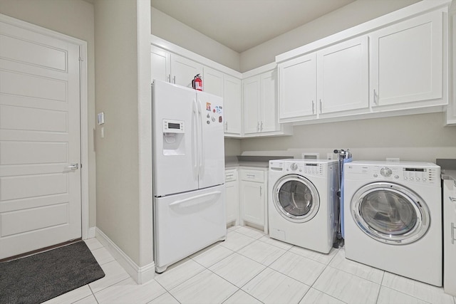 laundry area featuring cabinets, light tile patterned floors, and independent washer and dryer