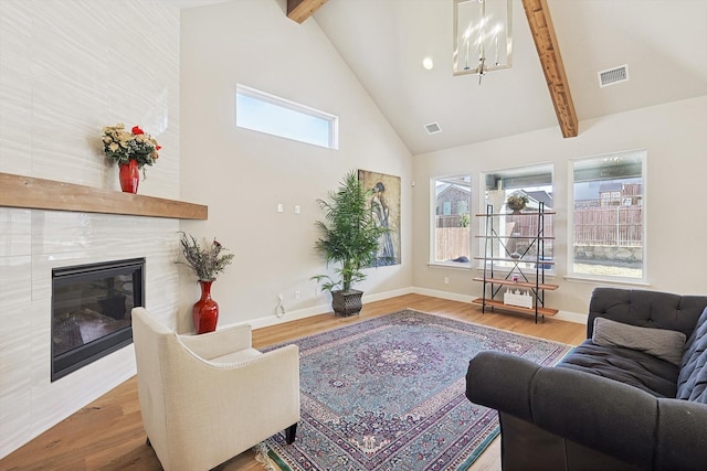 living room featuring plenty of natural light, beam ceiling, and hardwood / wood-style floors