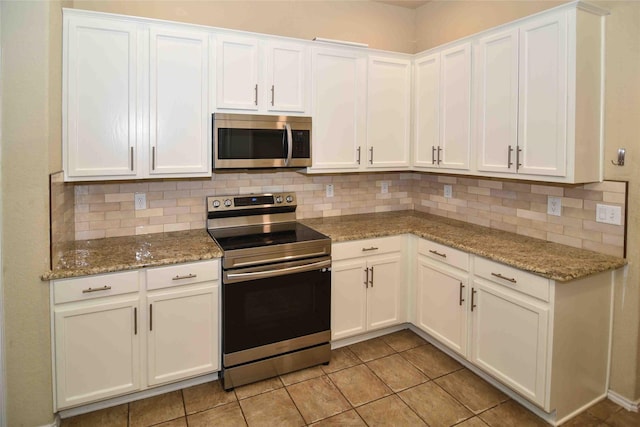 kitchen featuring backsplash, appliances with stainless steel finishes, and white cabinets