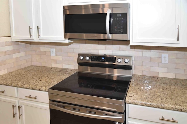 kitchen with white cabinetry, light stone countertops, tasteful backsplash, and stainless steel appliances