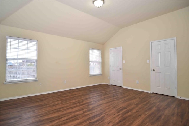 empty room with dark wood-type flooring and vaulted ceiling