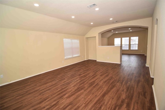 unfurnished living room with dark wood-type flooring and lofted ceiling