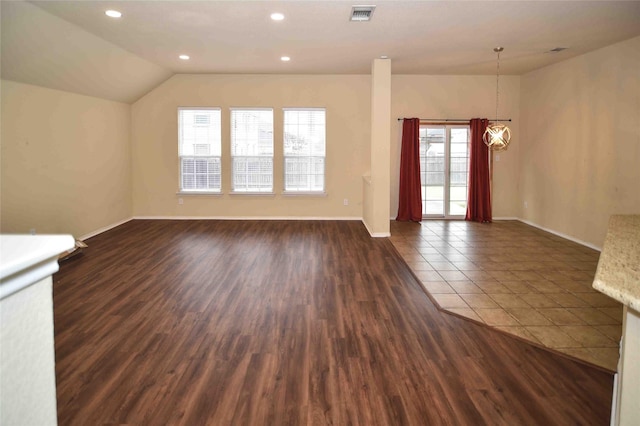 unfurnished living room with vaulted ceiling and dark hardwood / wood-style flooring