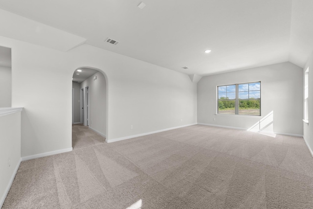 carpeted spare room with vaulted ceiling