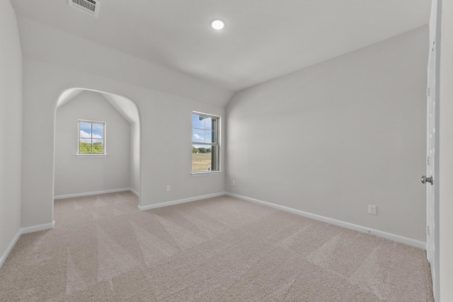 empty room with vaulted ceiling and light carpet