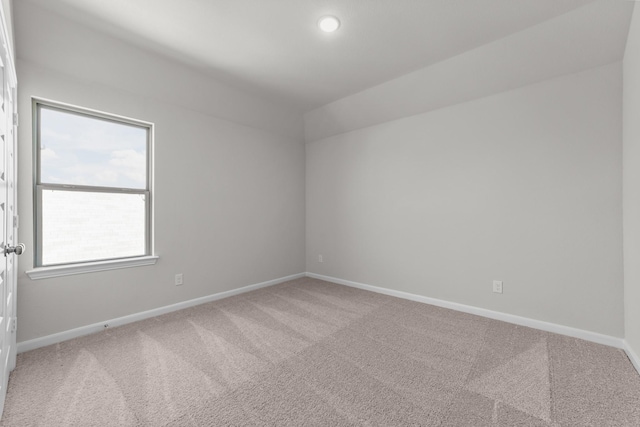 spare room with lofted ceiling and carpet flooring