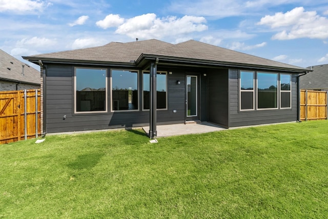 back of house with a patio area and a lawn