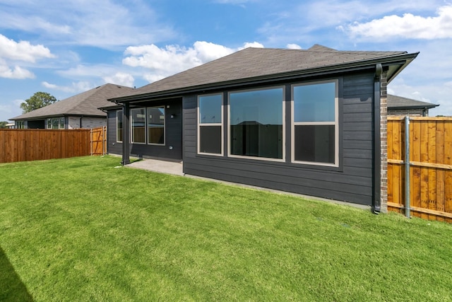 rear view of house featuring a patio and a lawn