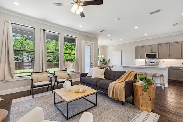 living room with dark hardwood / wood-style flooring, ornamental molding, and ceiling fan