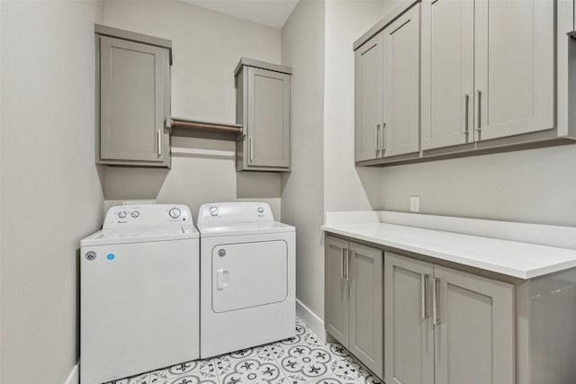 clothes washing area with separate washer and dryer, light tile patterned floors, and cabinets