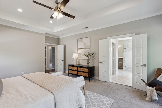 bedroom with light colored carpet, ceiling fan, and a tray ceiling