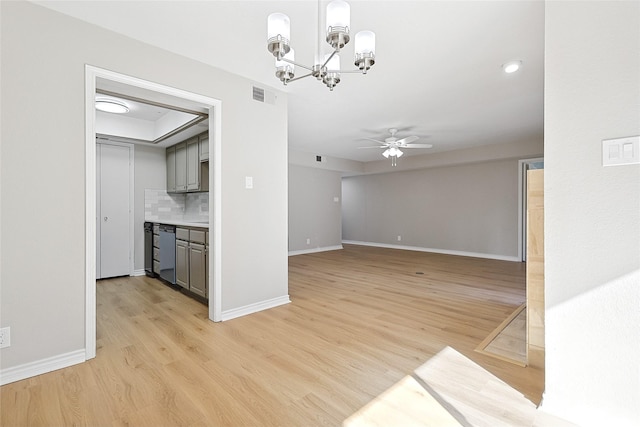 unfurnished living room with ceiling fan with notable chandelier and light wood-type flooring