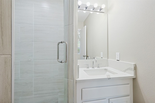 bathroom featuring vanity and a shower with door