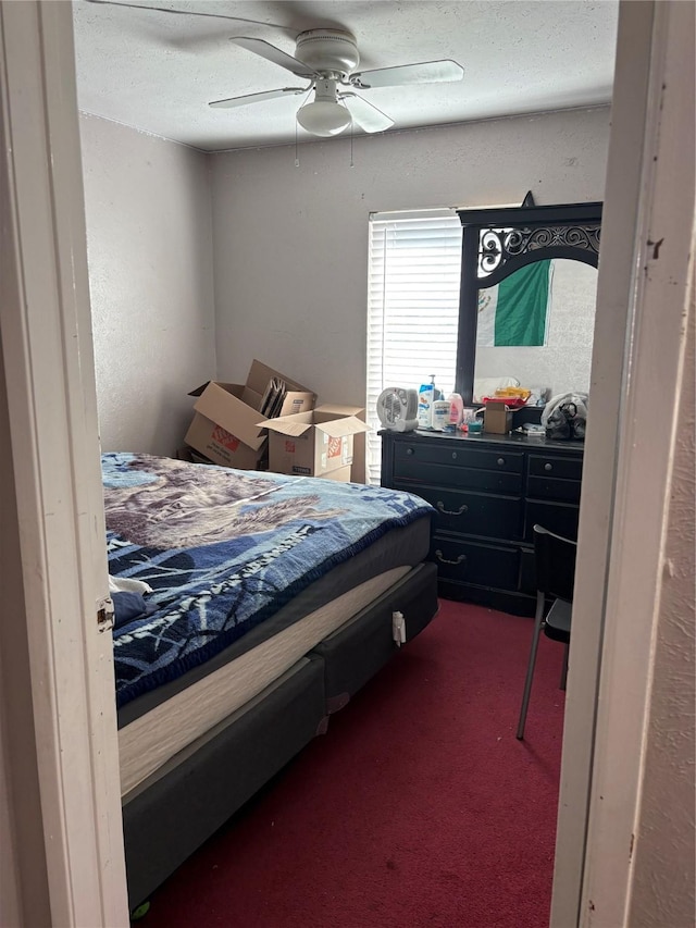 carpeted bedroom featuring ceiling fan and a textured ceiling