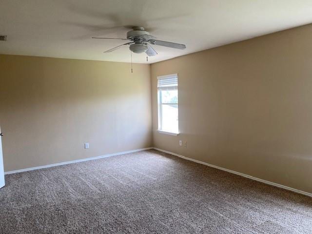 carpeted spare room with ceiling fan