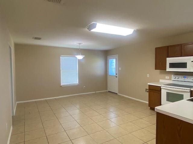 14029 Coyote Trl, Fort Worth, TX 76052 - kitchen with light tile patterned floors, white appliances, baseboards, decorative light fixtures, and light countertops
