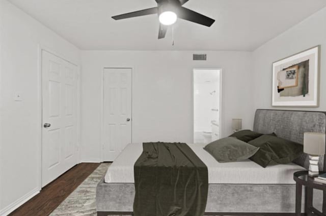 bedroom with ceiling fan, connected bathroom, and dark hardwood / wood-style flooring