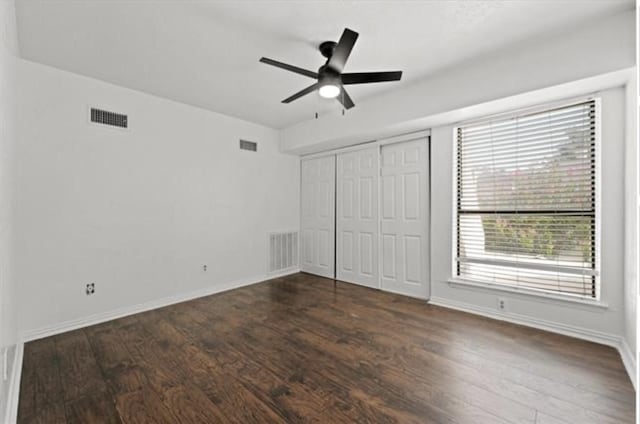 unfurnished bedroom featuring a closet, dark hardwood / wood-style floors, and ceiling fan