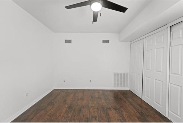 unfurnished bedroom featuring dark wood-type flooring, ceiling fan, and a closet